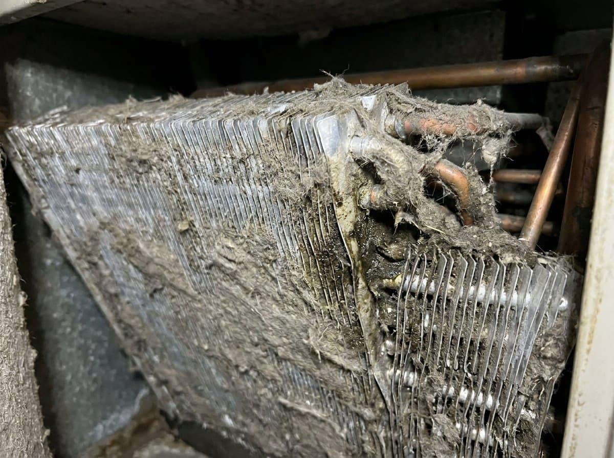 AC evaporator coil before and after cleaning, clogged dusty fins restored to clean aluminium