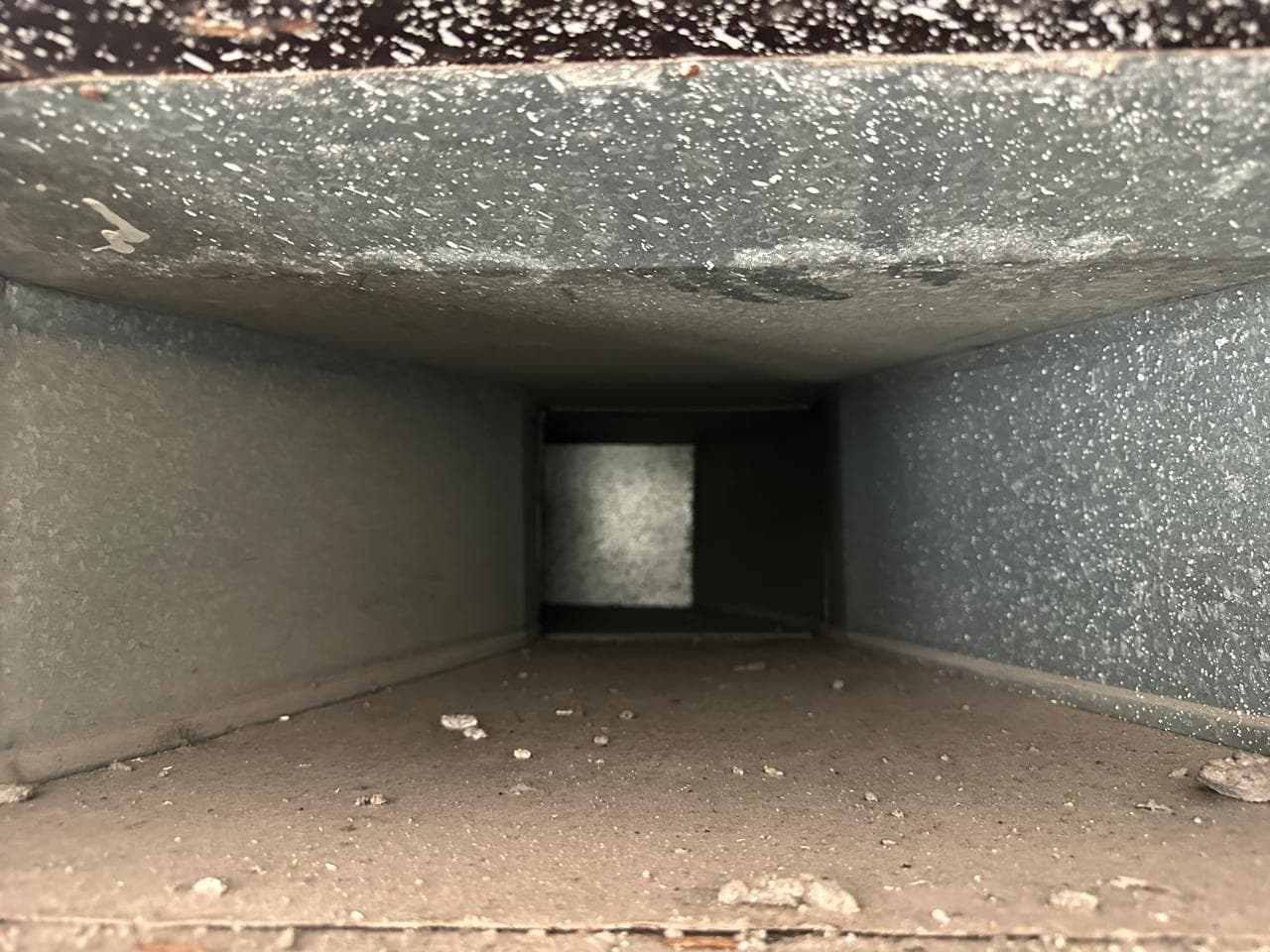 Blocked, dusty AC duct before and after cleaning, airflow restored