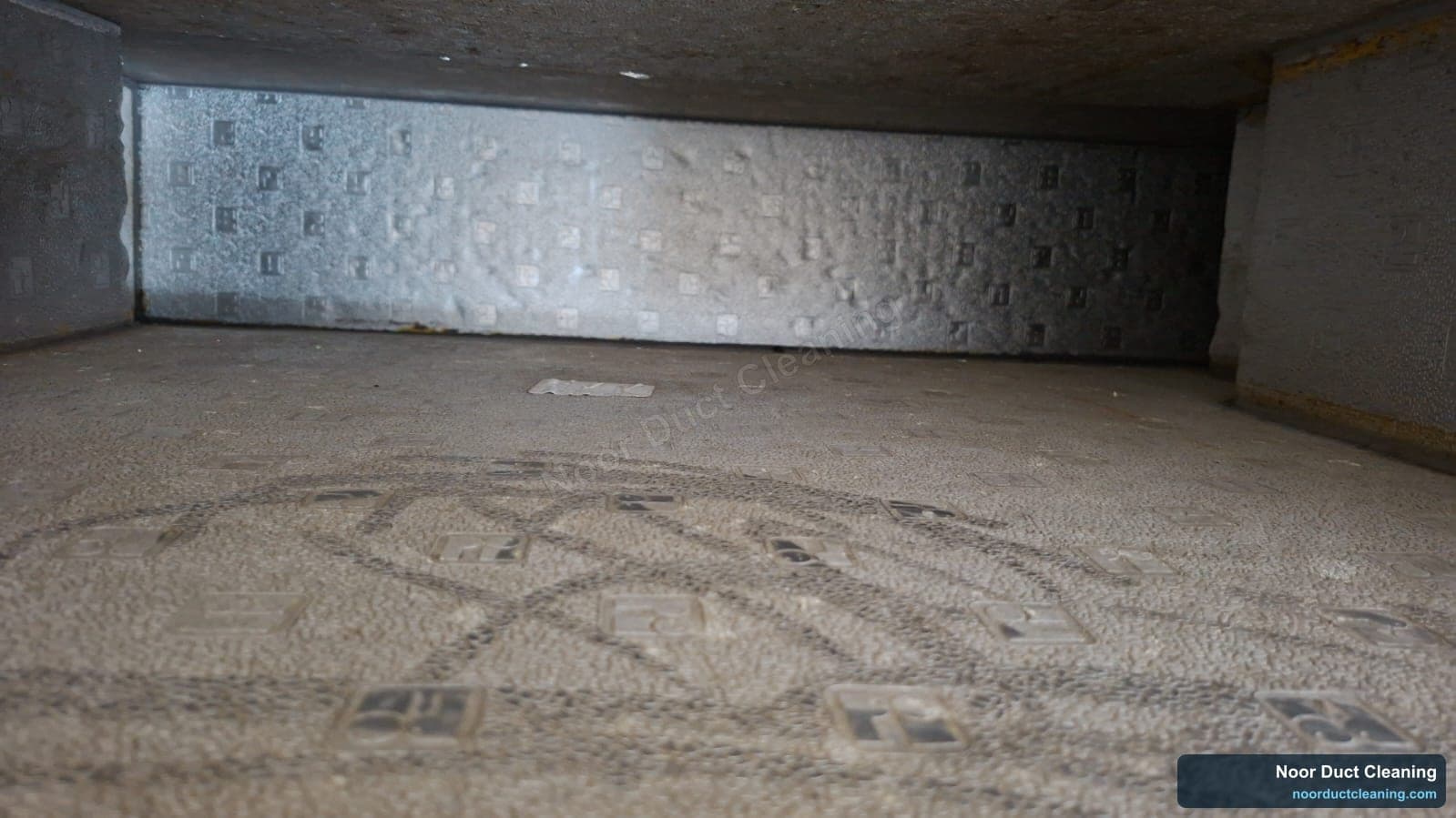 Rectangular galvanised AC supply duct in a Dubai property before and after cleaning, a film of settled dust on the duct floor lifted back to clean metal